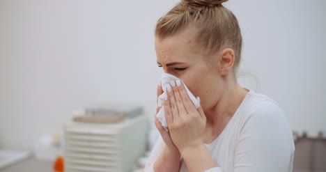 sneezing woman has coronavirus symptoms