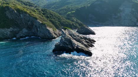 costa rocosa rodeada de aguas azules cristalinas con la luz del sol reflejada por las olas