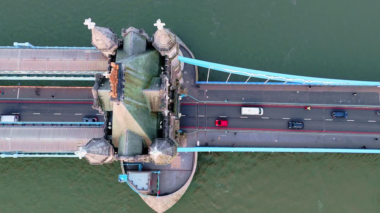 Pedestrians and traffic crossing iconic Tower Bridge, aerial panning