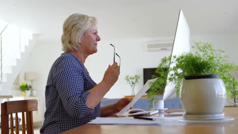 Senior-woman-looking-at-documents-at-home-4k