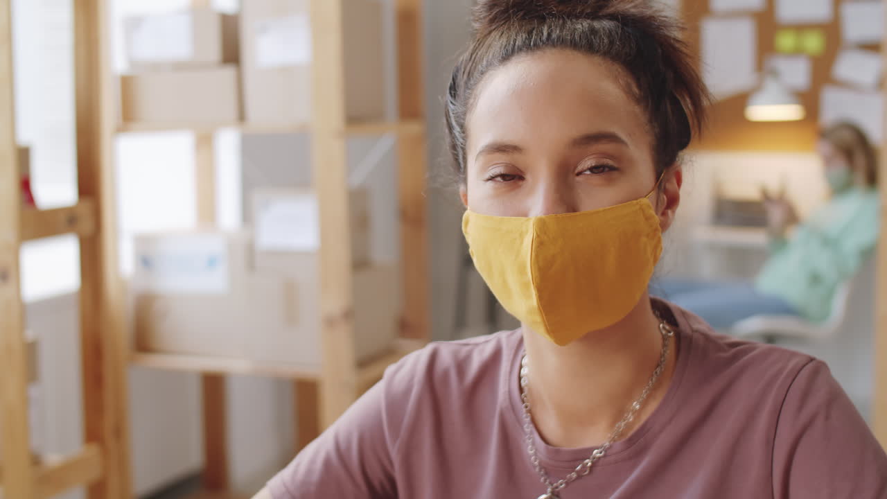 オフィスでマスクをかぶった女性