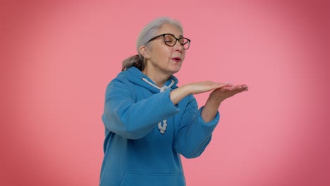 Mature-old-granny-woman-showing-wasting-or-throwing-money-around-hand-gesture,-more-tips,-big-profit