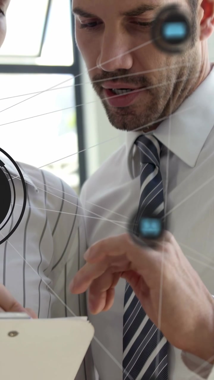Dikey video: Tablet tutan kadına bakan adam, ikisi de artırılmış gerçeklik (AR) simgeleriyle iş grafiklerine dokunuyor.