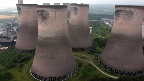 disused industrial energy power plant cooling smoke stake chimneys aerial view high dolly left