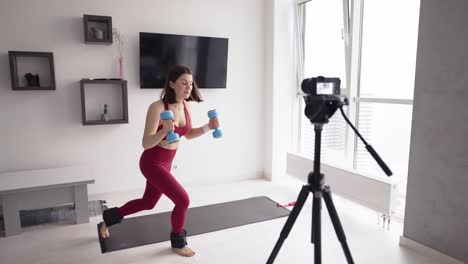 woman fitness instructor records a tutorial training with dumbbells