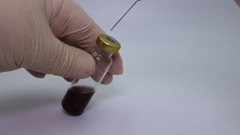 técnico de laboratorio inyecta líquido en un tubo de ensayo con una jeringa