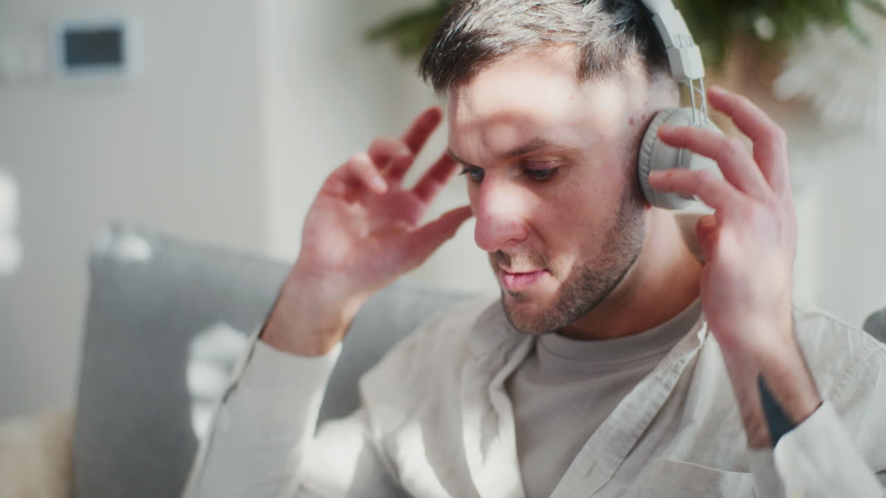 primer plano de un hombre trabajando remotamente en una computadora portátil con auriculares