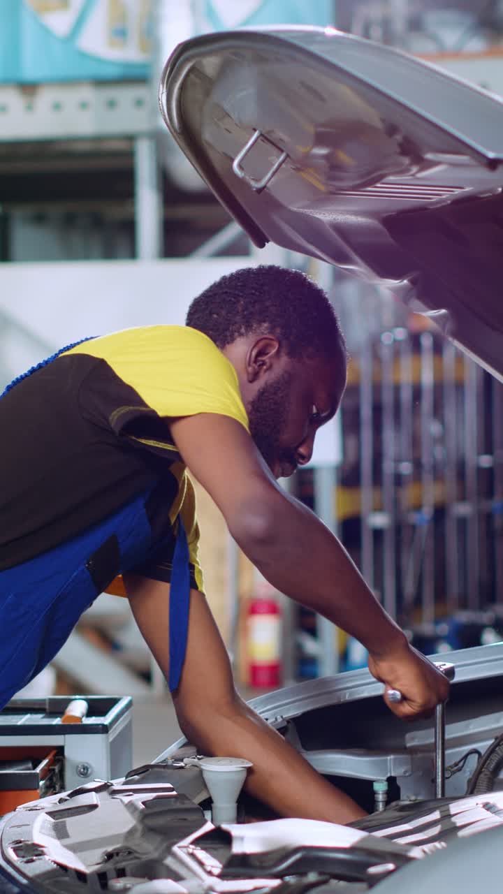 Vertical video Technician in car service uses wrench