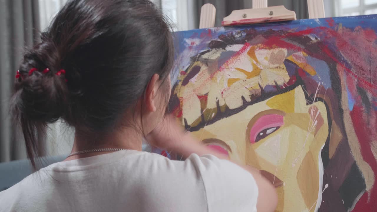 Back View Of Talented Female Artist Sitting On Wheelchair, Enthusiastically Using Paint Brush She Creates With Oil Painting. Creative Studio With Canvas