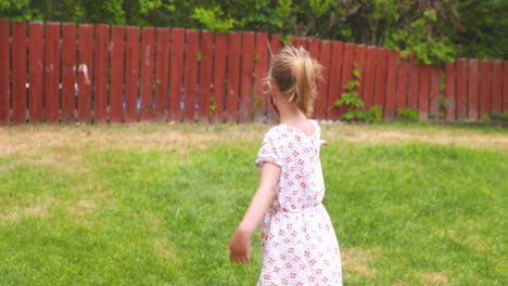 little girl playing outside while wearing a protective face mask