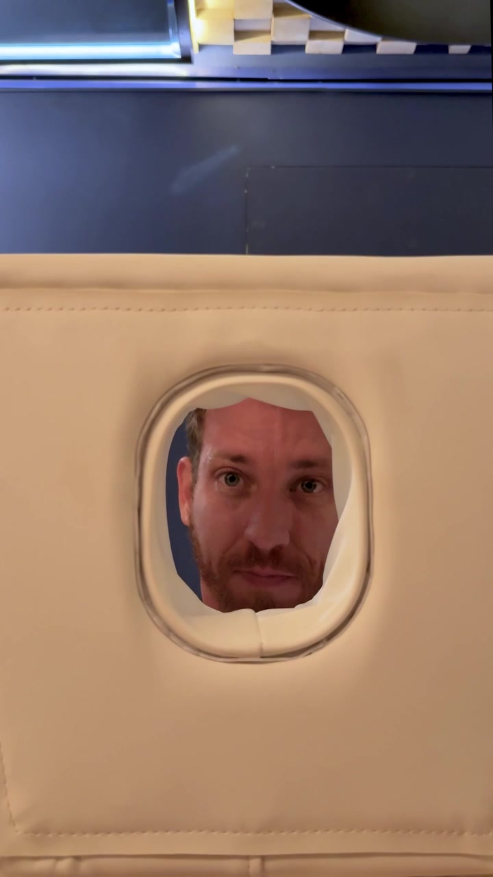 Massage bed POV. A man lies face down on a massage bed with his face positioned inside the padded headrest opening. vertical footage from beneath the massage table, showing an unusual spa perspective