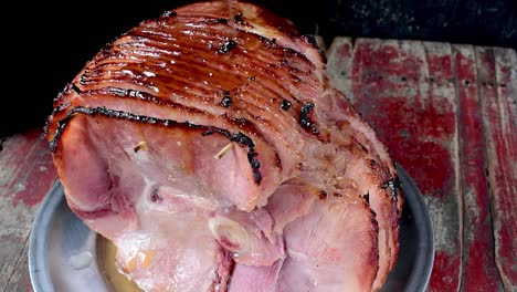 pouring syrup glaze over baked spiral cut ham