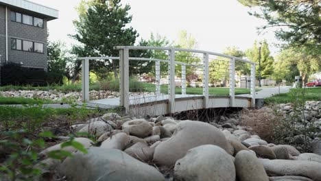 Idyllische-Weiße-Fußgängerbrücke-In-Einem-Kleinen-Außenpark-Mit-Herbstbäumen-Und-Weißen-Steinen---Statisch