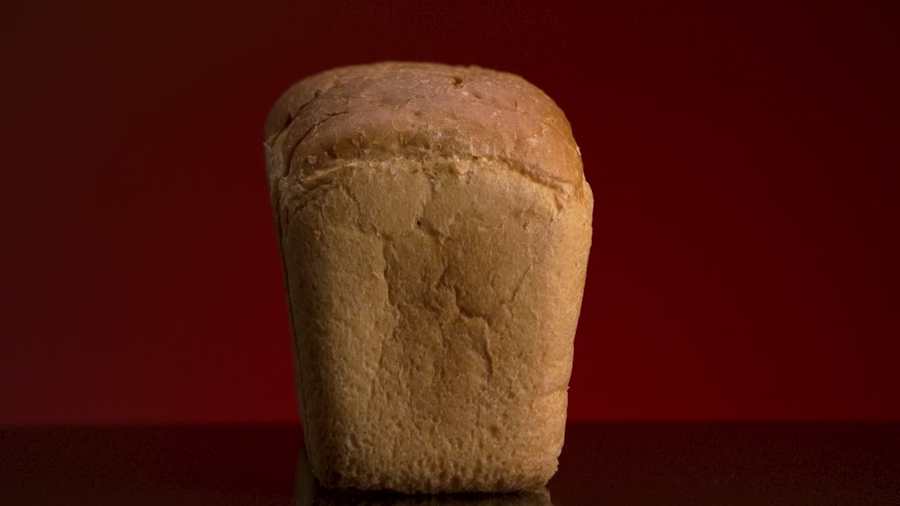 Hand reaching for a loaf of bread