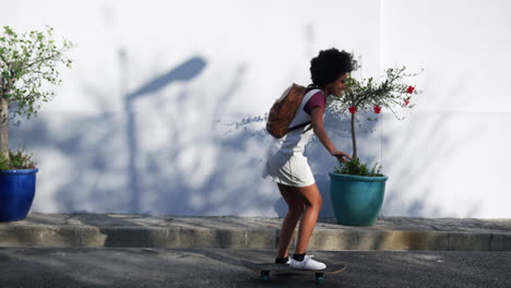 mixed race woman riding skateboard on street