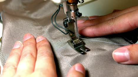 seamstress stitching cloth on sewing machine