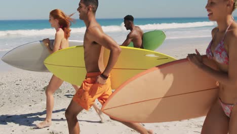 amigos adultos jóvenes corriendo en la playa 4k