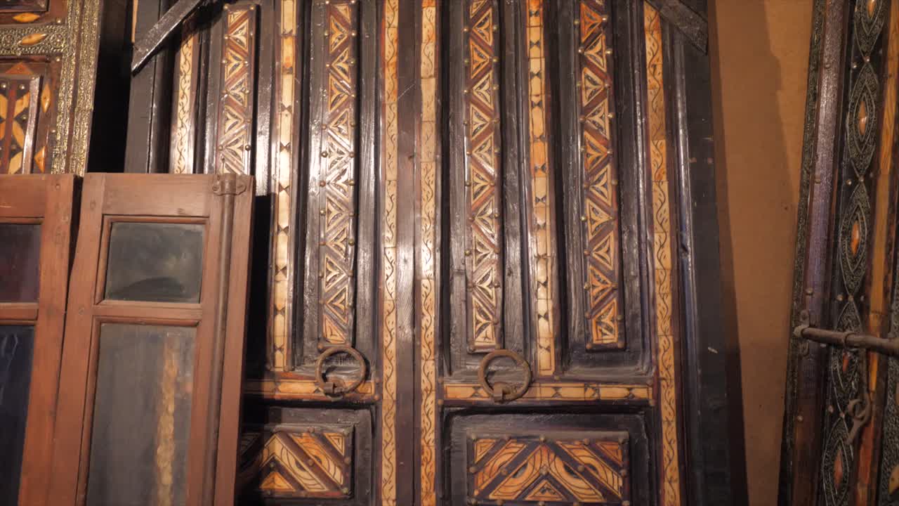 Close-up view of an antique Arabic house door with knocking and locking latch; beautiful old brown wooden door.