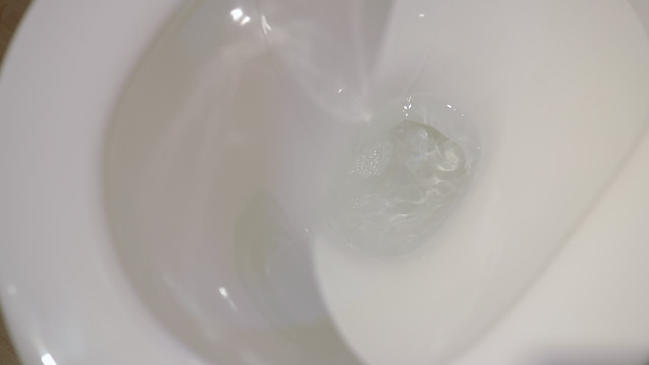 Slow Motion Mid Shot Of A Toilet Flushing Water