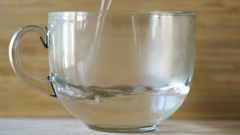 pouring water into a glass mug