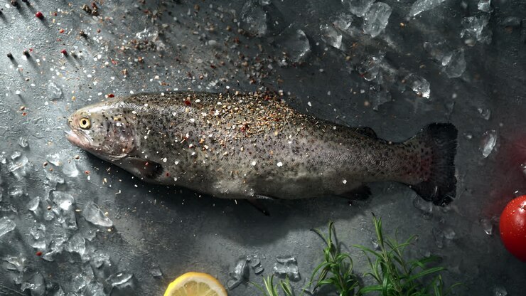 Seasoning Trout Fish Lying On A Chilled Stone Ice-Covered Kitchen Counter, Table Top View, Slow Motion