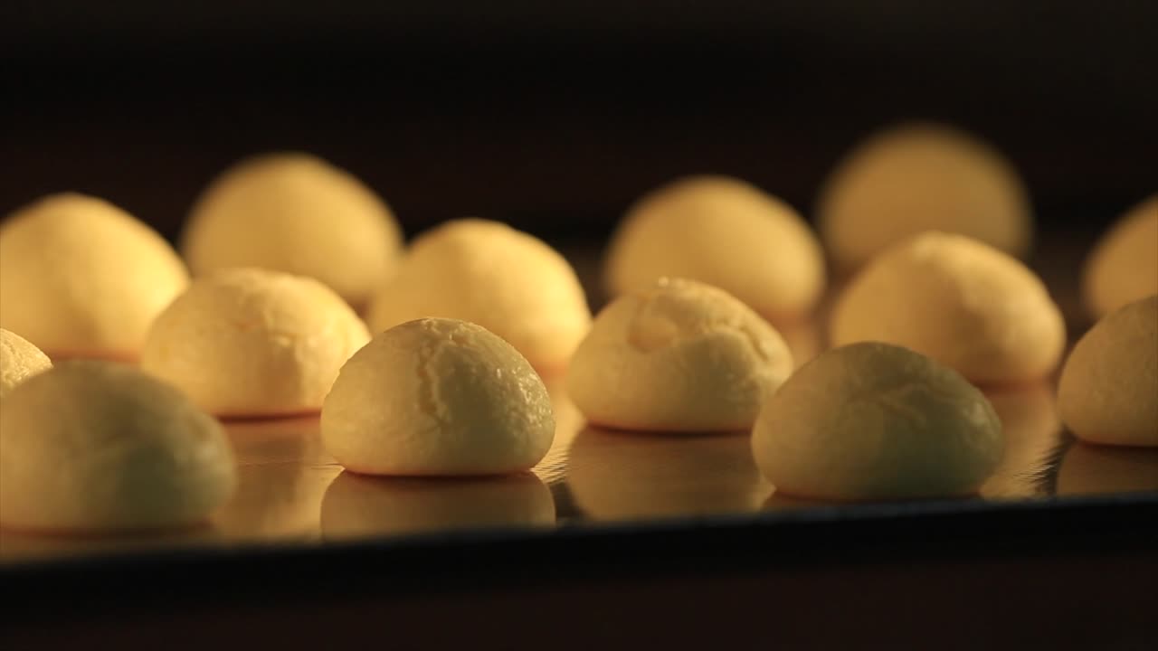 Time lapse of making fresh cookies in oven, baking and rising, on black background. Front view.