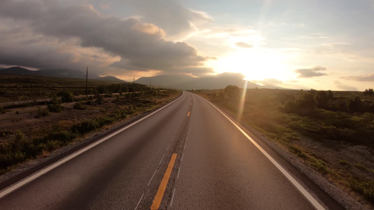 Dirigindo um carro em uma estrada na Noruega ao amanhecer