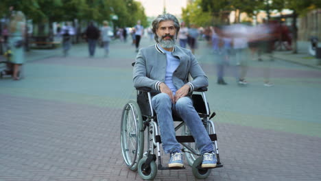 hombre en silla de ruedas en la calle de la ciudad