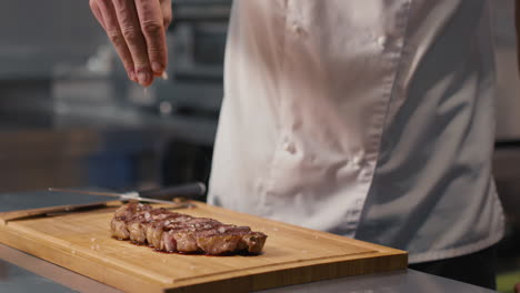chef salting prepared steak