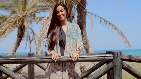 Mujer-Joven-Y-Bonita-Apoyada-En-La-Barandilla-En-La-Playa