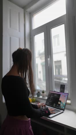 mujer trabajando en una computadora portátil en casa