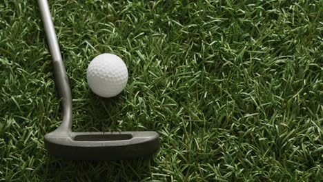 close up of golf club and balls on grass, copy space, slow motion