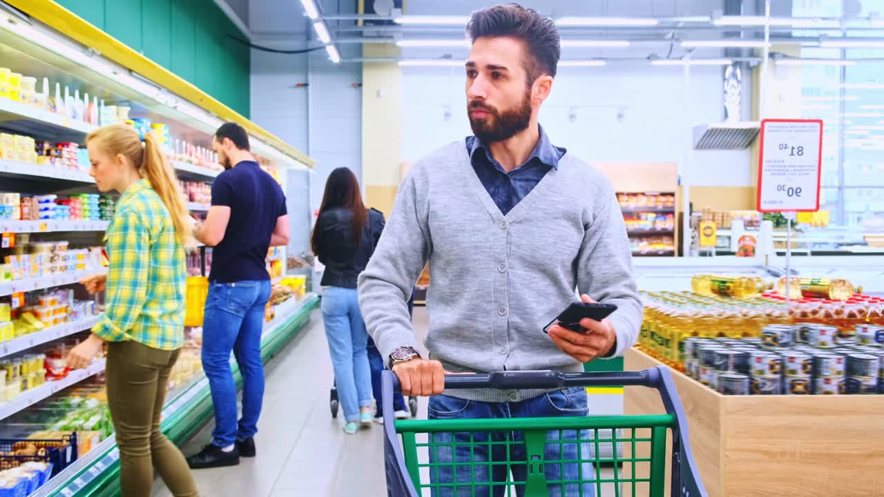 A Man Shopping in a Supermarket, Intently Selecting Products While Pushing a Cart, Surrounded by Colorful Shelves Filled with Various Grocery Items
