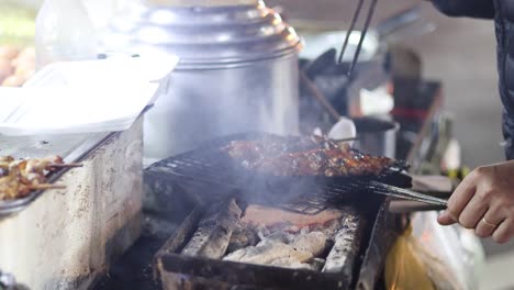 vendor skillfully grills meat on a busy street