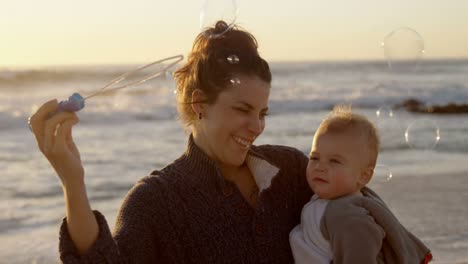 mother and baby boy playing with bubble wand 4k