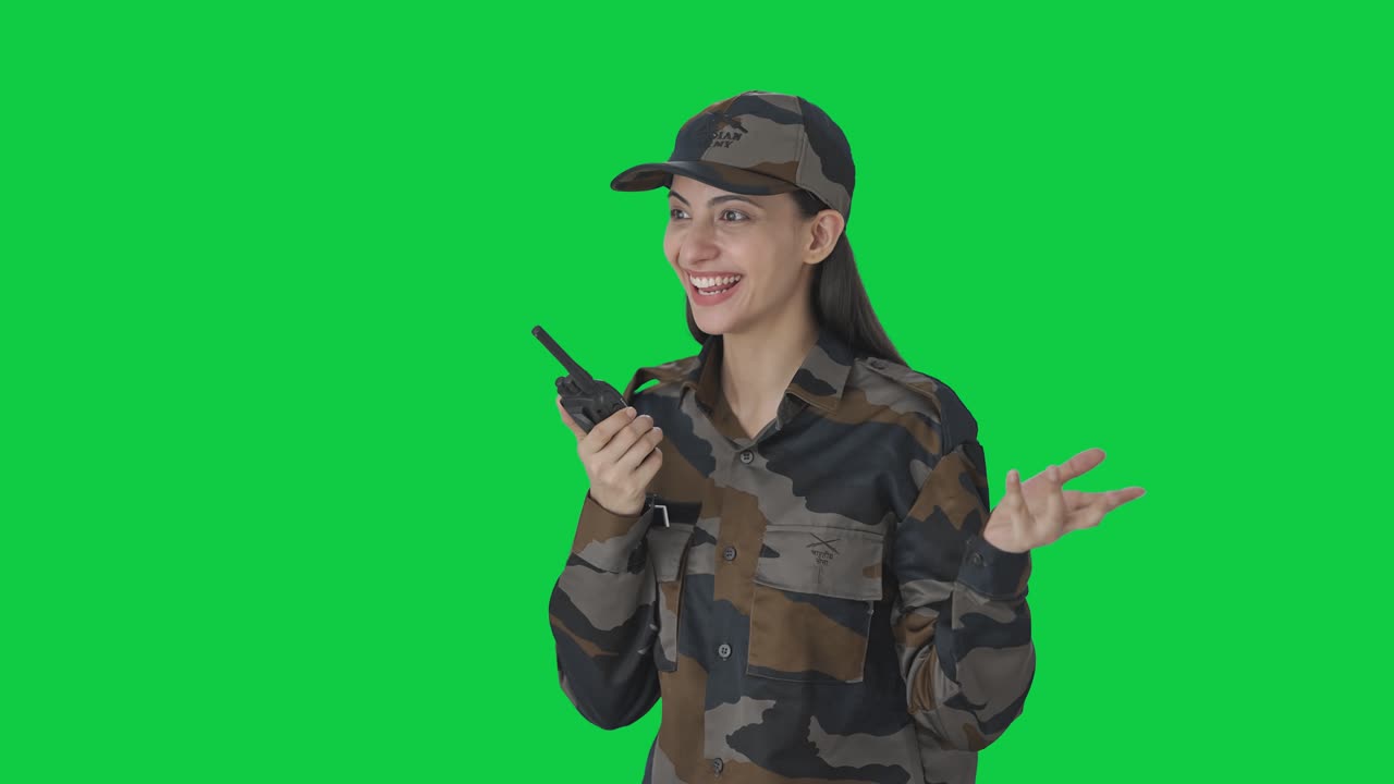 Felice ufficiale donna dell'esercito indiano che parla al walkie-talkie. Schermo verde.