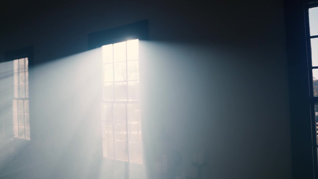 Dramatic Sunbeams Streaming Through Dusty Window in a Dark Room