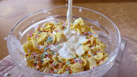 flocos de maíz amarillos crujientes en el cuenco para la mañana un delicioso desayuno con leche. cámara lenta con toma de seguimiento de rotación.