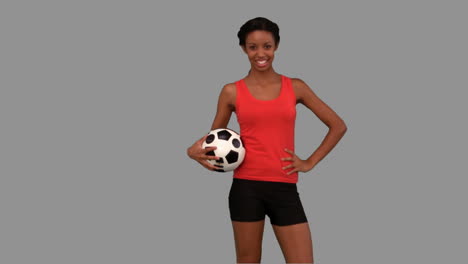 mujer atrapando un fútbol en la pantalla gris