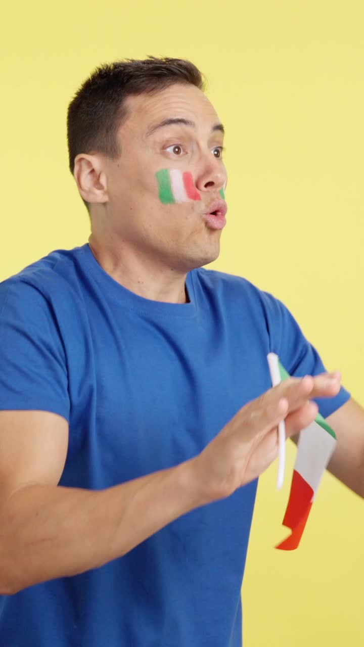 Italian supporter screaming and waving a national flag looking away