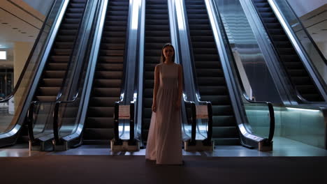 woman in dress in front of escalators