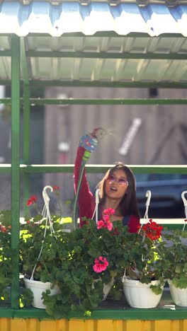 woman watering flowers at a market stall