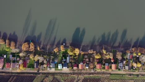 Line of houses at the lake with beautiful shadows on the water because of the sunset. Autumn colors