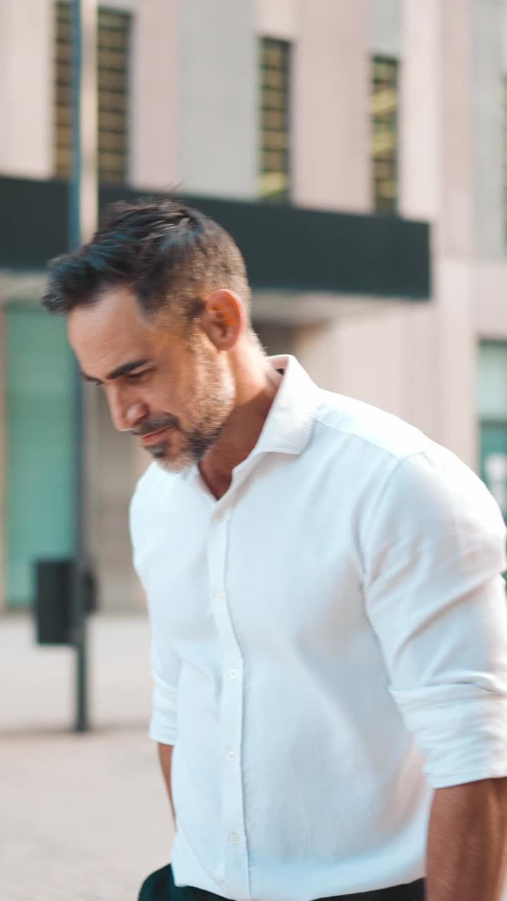 Uomo con camicia bianca che cammina all'aperto
