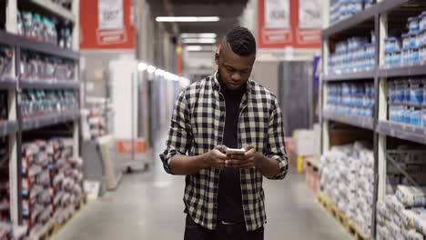 Man-with-a-phone-shopping-at-a-warehouse-store