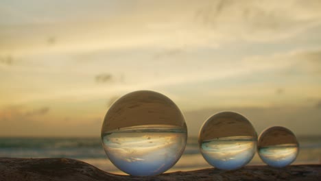 three crystal balls in golden sunset on a timber.