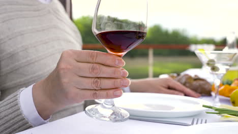 close up of a woman's hand holding a glass of wine