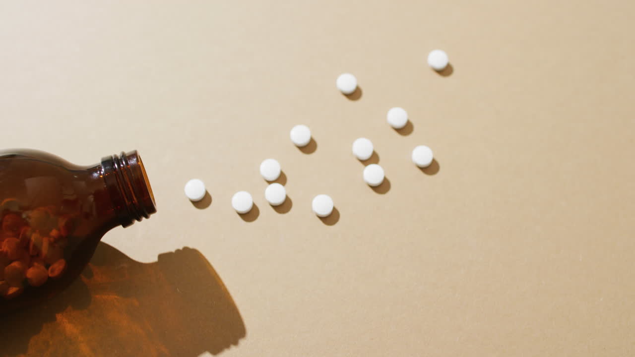 복사 공간과 함께 갈색 배경에  ⁇  알약을 흘리는 갈색 병의 비디오