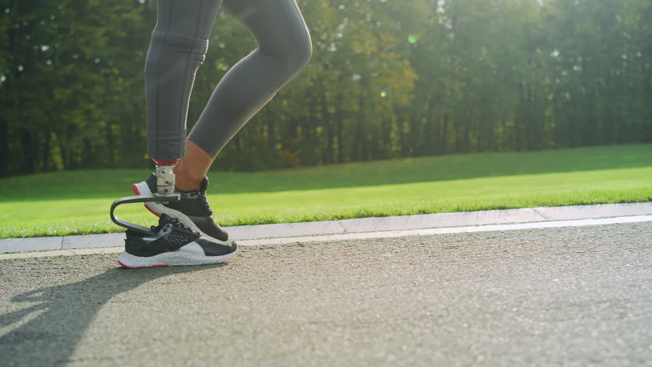 Donna con disabilità con scarpe sportive che corre sulla strada. Piedi di ragazza che si allenano all'aperto.