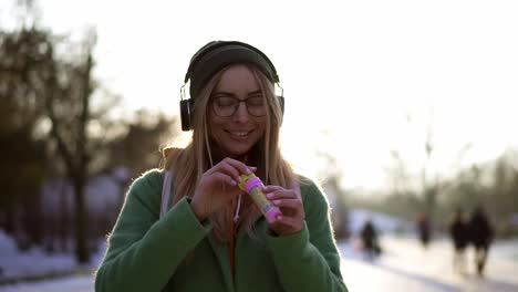 young woman inflates soap bubbles in the winter during the cold weather